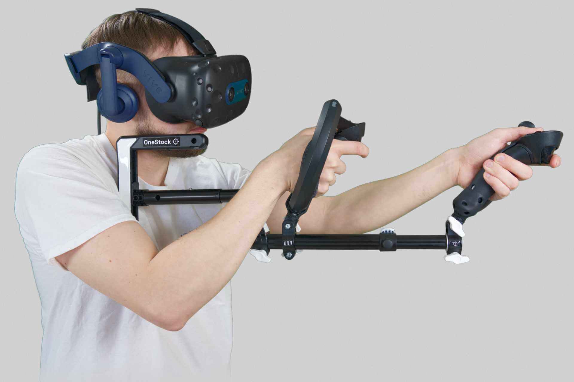 Homme tenant un modèle Valve Index Wield VR OneStock VR gunstock sur fond gris 